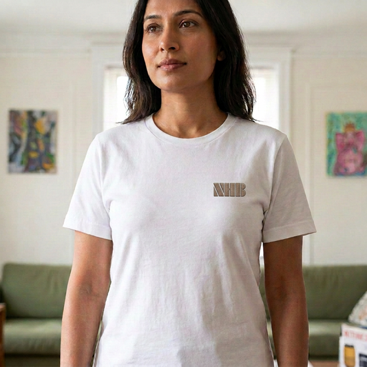 Model wearing white NHB tee with tan embroidered chest logo